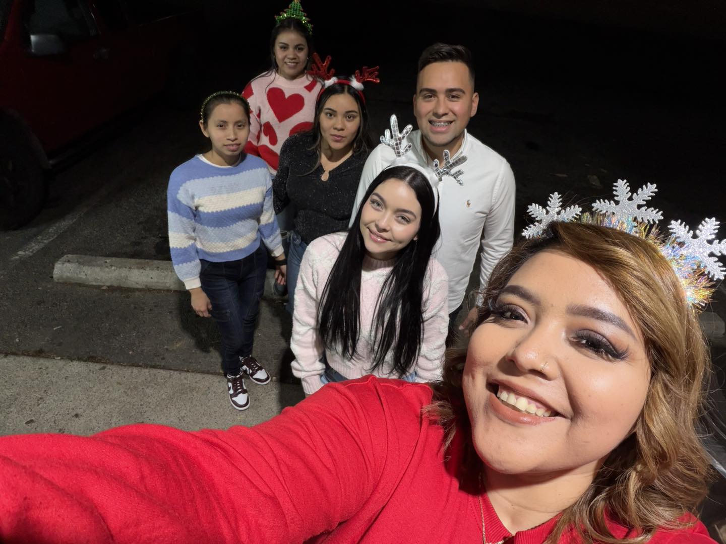 The Luna family and team together outdoors at night — festive holiday group photo.